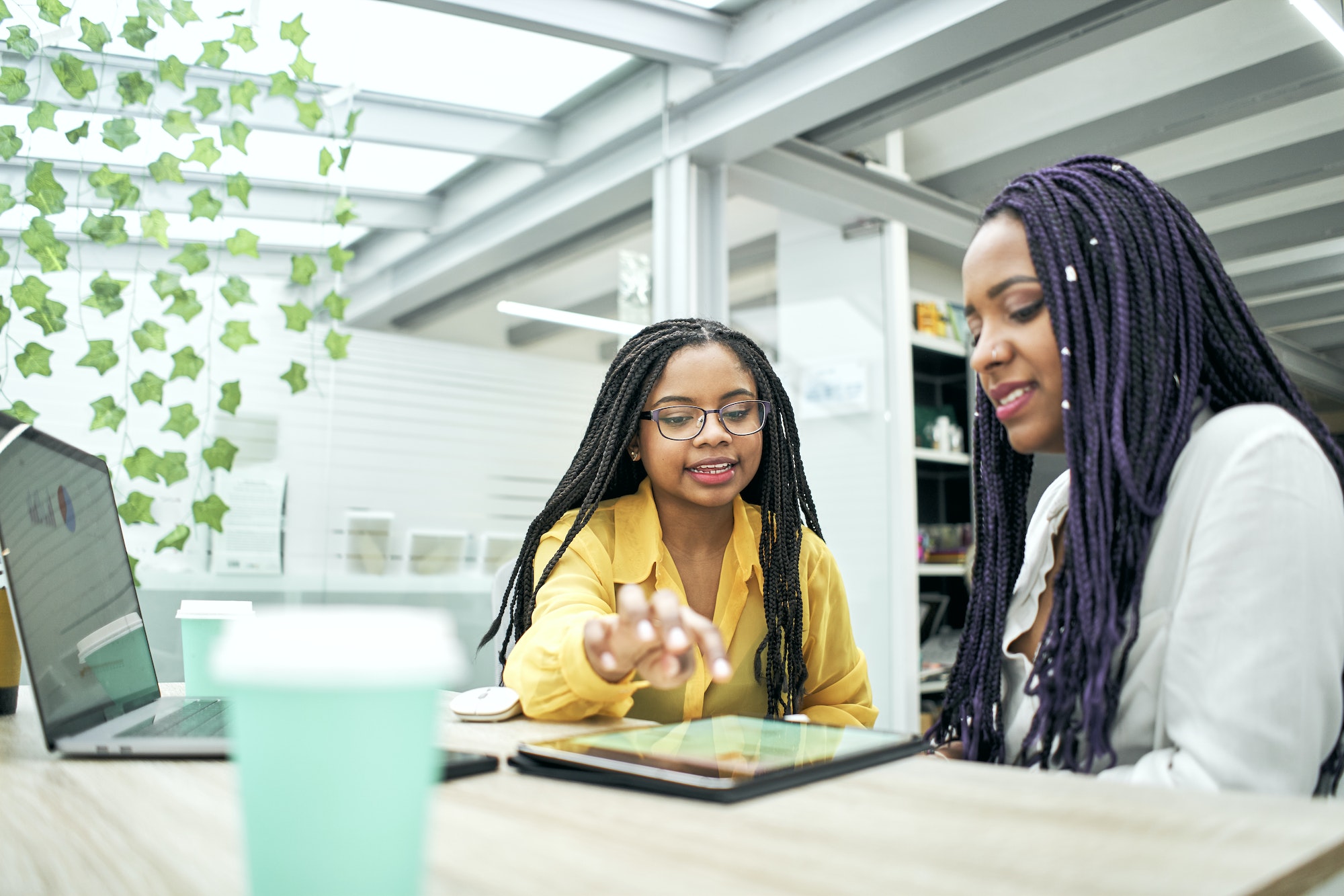 Two business girls using a tablet in the office.
